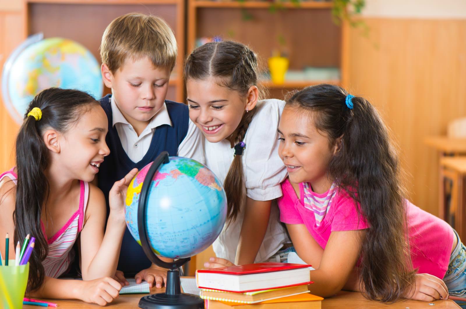 Four students looking at a globe